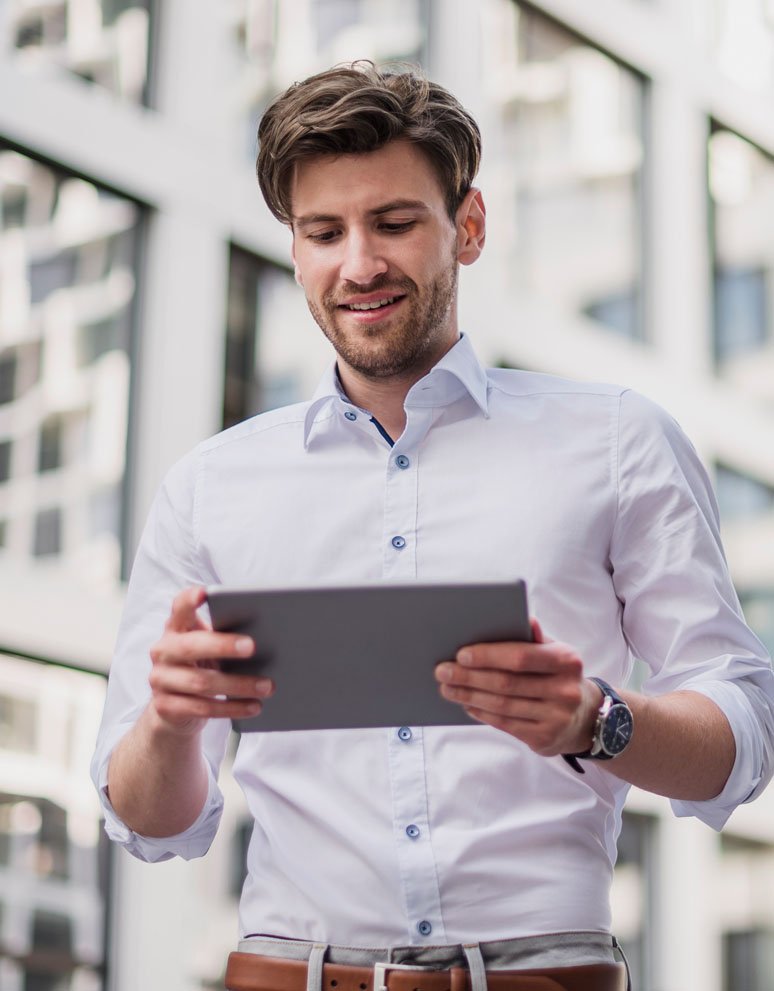 smiling-businessman-in-the-city-using-tablet-7V9MCSC.jpg